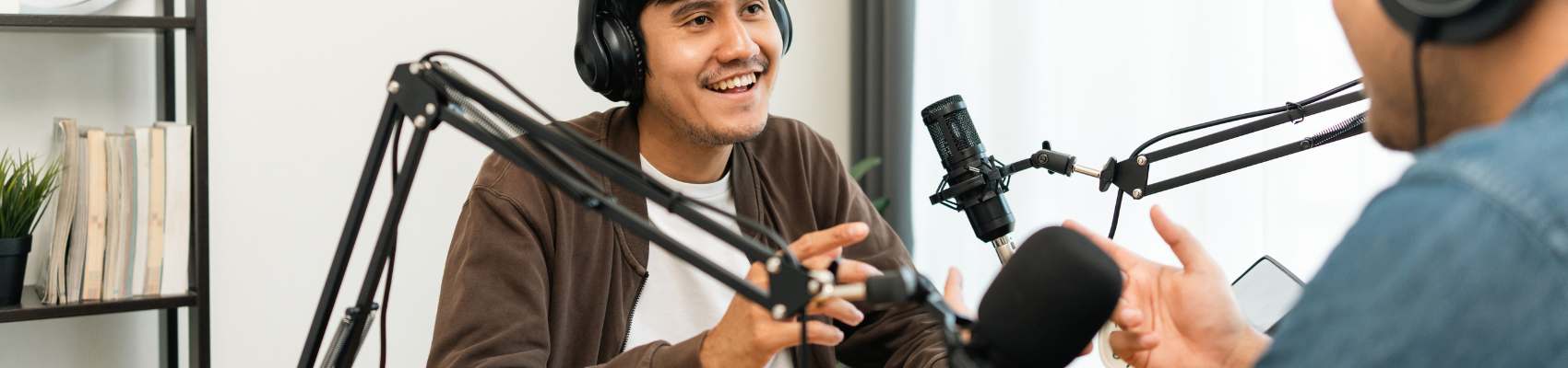 picture of two people talking in a recording study using microphones