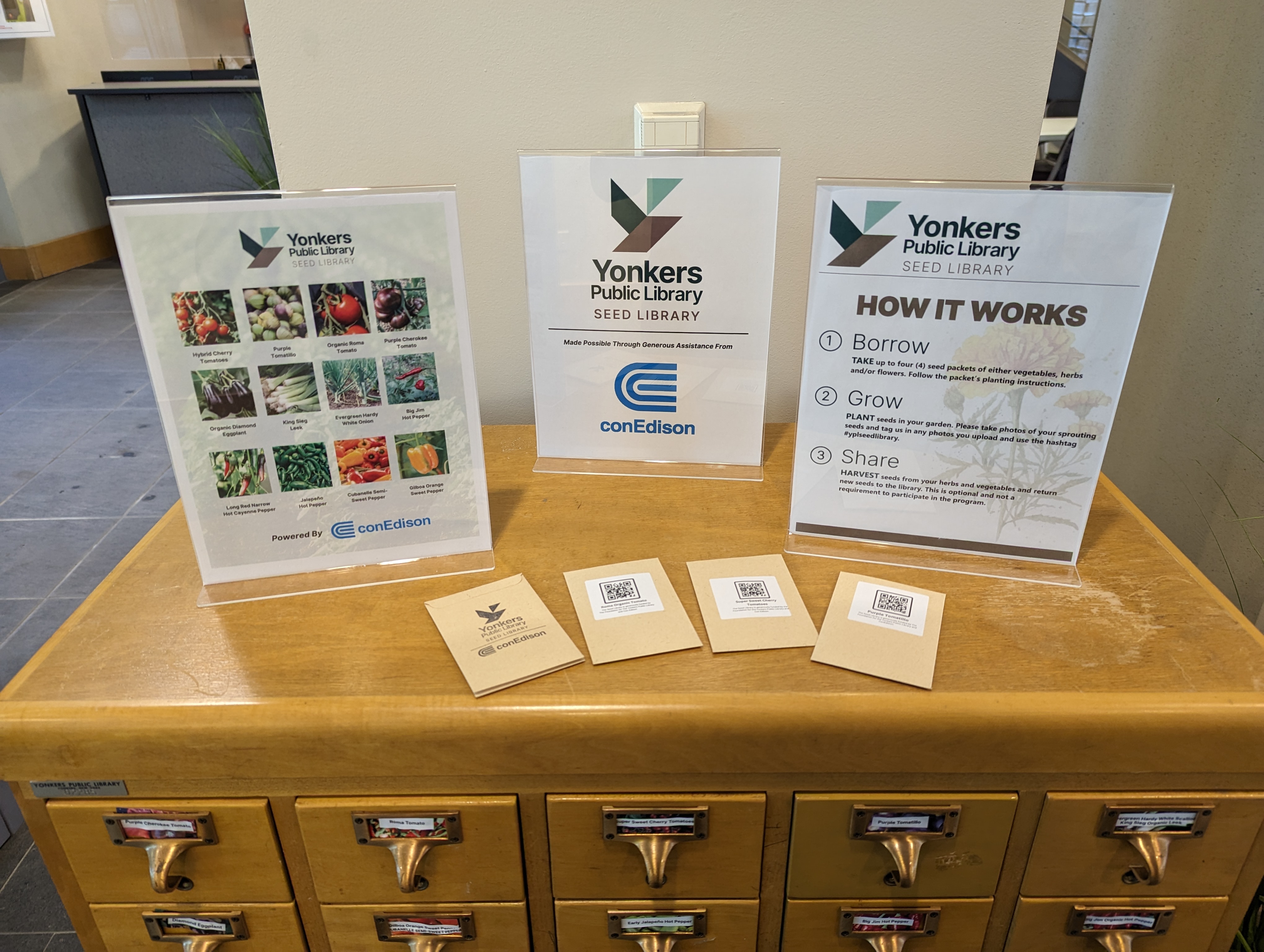 Seed library signs on a card catalog with YPL seed library packets