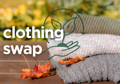 Folded sweaters on a table with the graphic of a hand holding a tree sapling with the text: clothing swap.