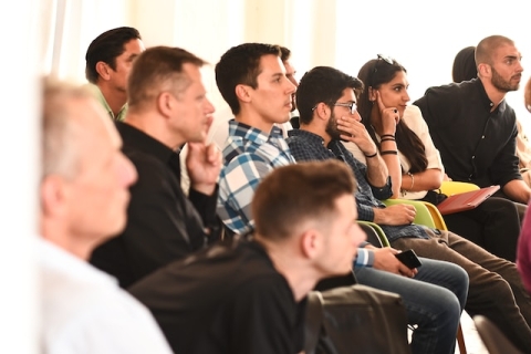 group of people seated and listening. 