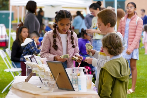 photo of kids at a table selling things