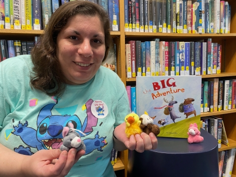 photo of Liz Caruso with StoryPal stuffed animals and an adventure book