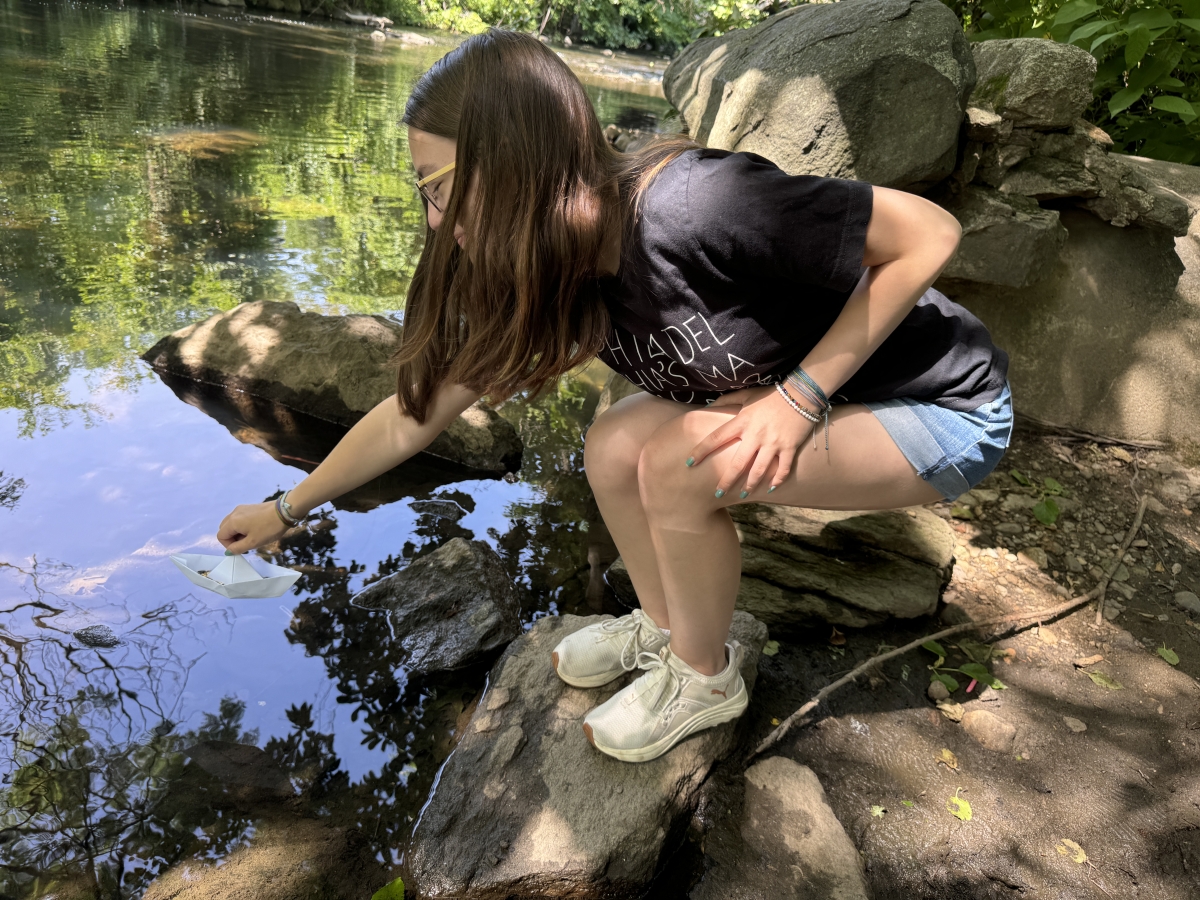 Image of Carina putting a dissolvable boat into the river