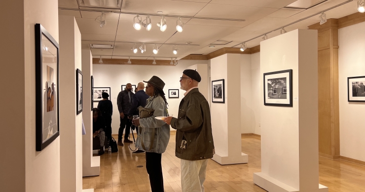 Patrons admiring works on the rolling walls during the Breathe In The Sky Opening Reception