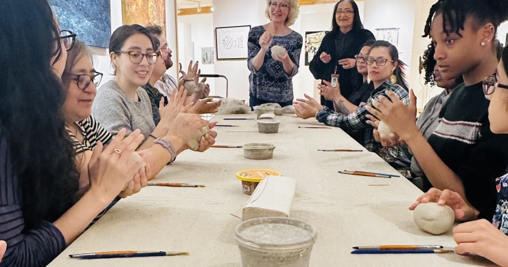 Patrons patting their clay during the art gallery's ceramic bowl making class